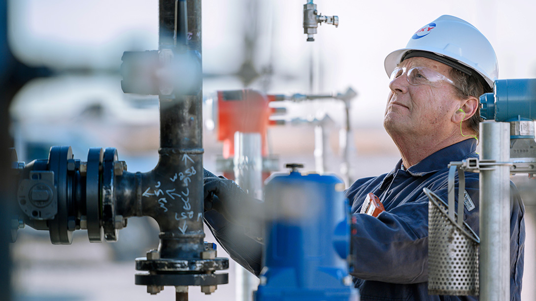 Male Oxy employee working on valves in field