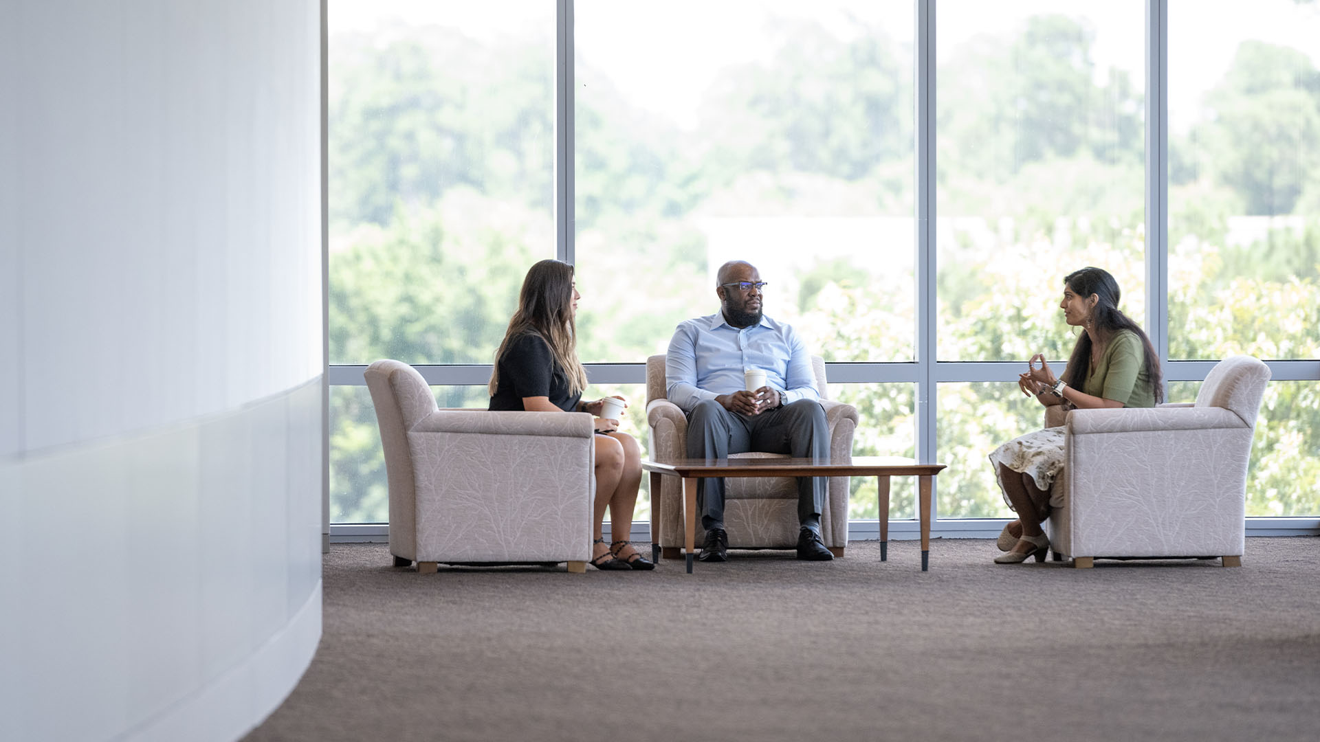 Three Oxy employees sitting around a coffee table